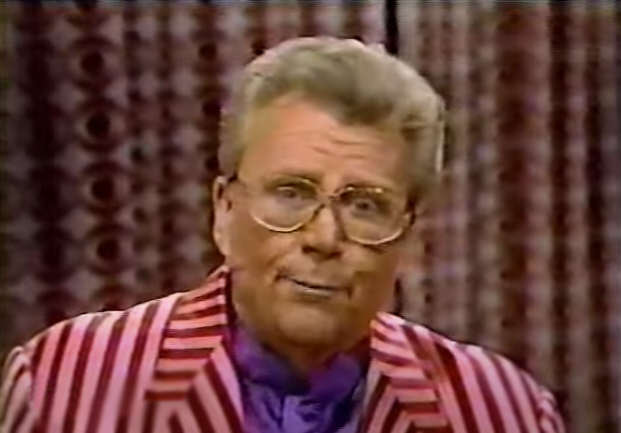 Rod is wearing a red and pink striped jacket & purple silk collarless shirt