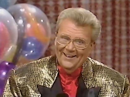 Rod is wearing a gold-sequin jacket w/black lapels & a red collarless silk shir t