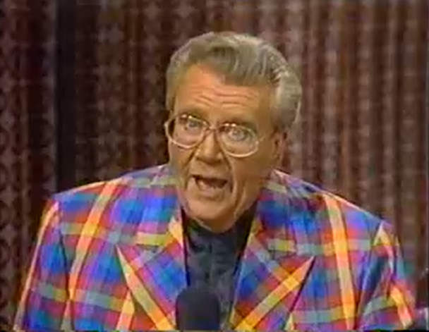 Rod is wearing a multi-colored gingham jacket & black collarless silk shirt