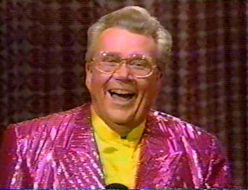 Rod is wearing a shiny fuchsia/fuchsia-striped jacket & yellow collarless silk shirt