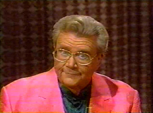 Rod is wearing a pink jacket & dark-green collarless silk shirt