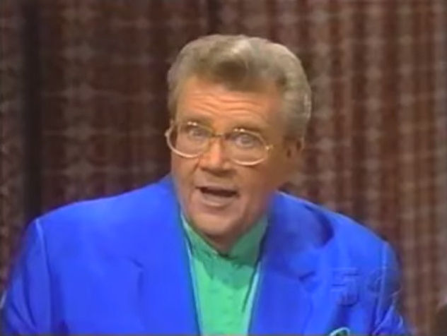 Rod is wearing a blue jacket & teal-green collarless silk shirt