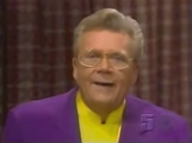 Rod is wearing a purple jacket & yellow collarless silk shirt
