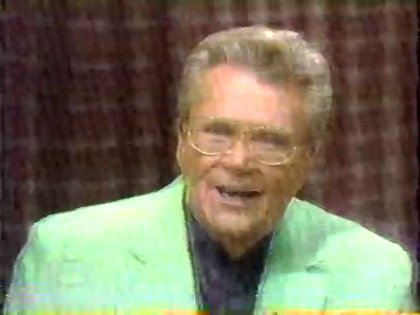 Rod is wearing a mint-green jacket & black collarless silk shirt