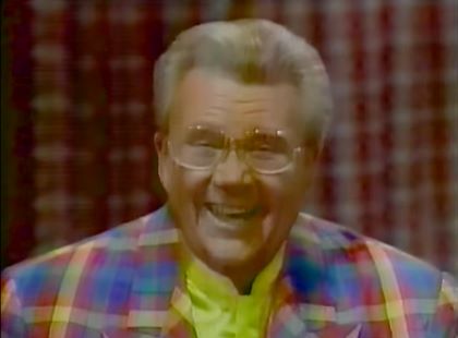 Rod is wearing a multi-colored gingham jacket & yellow collarless silk shirt