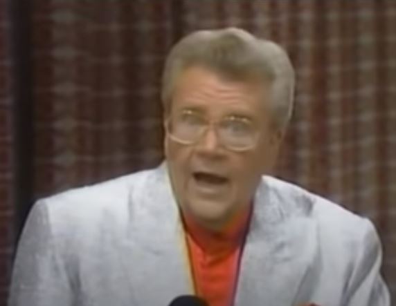Rod is wearing a silver jacket & red silk collarless shirt