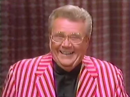 Rod is wearing a red and pink-striped jacket & black collarless silk shirt