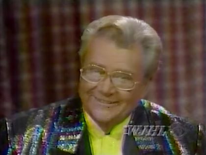 Rod is wearing a rainbow-sequined jacket with black lapels & yellow collarless silk shirt