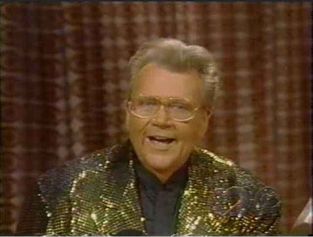 Rod is wearing a gold sequined jacket & black collarless silk shirt