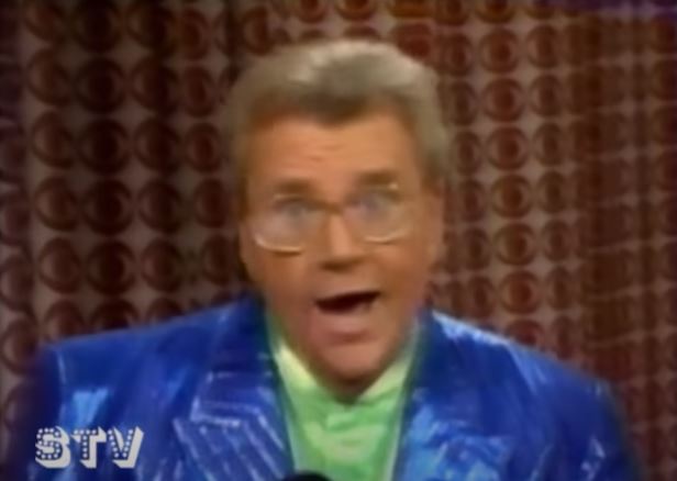 Rod is wearing a shiny blue/blue-striped jacket & lime-green silk collarless shirt