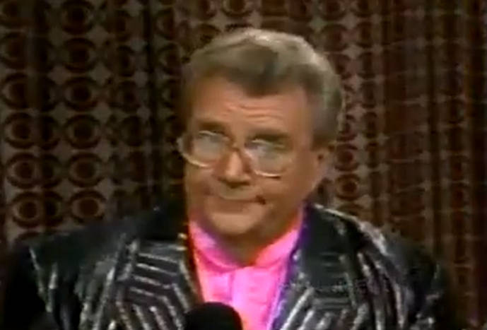 Rod is wearing a shiny black jacket with silver stripes & pink collarless silk shirt