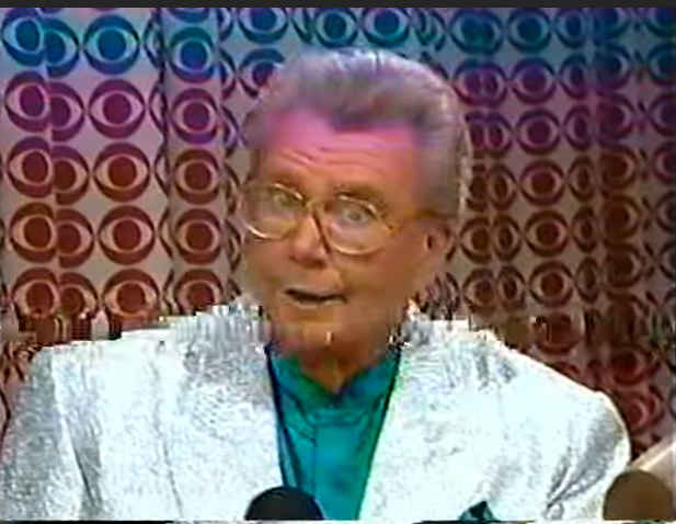 Rod is wearing a silver sequined jacket & dark-green collarless silk shirt