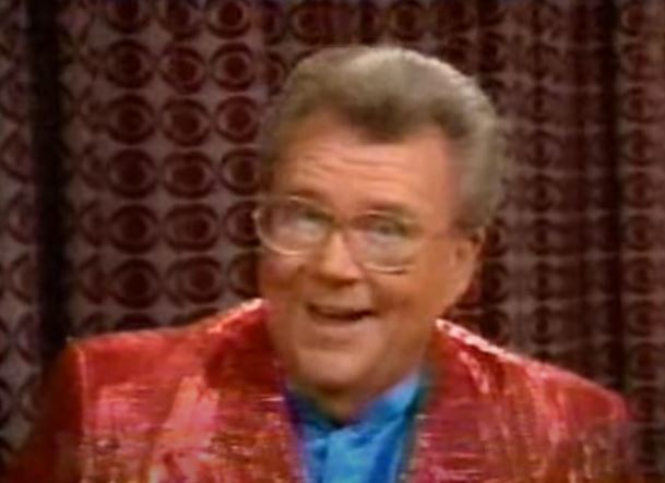 Rod is wearing a reddish sequined jacket & powder-blue silk collarless shirt