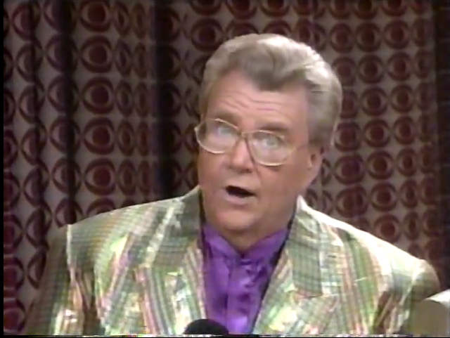 Rod is wearing a shiny gold-holographic jacket & purple collarless silk shirt