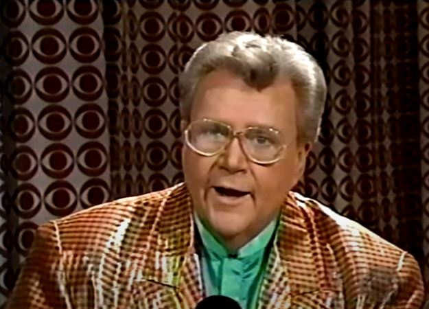 Rod is wearing a shiny honey-colored/black-patterned jacket & lime-green silk collarless shirt