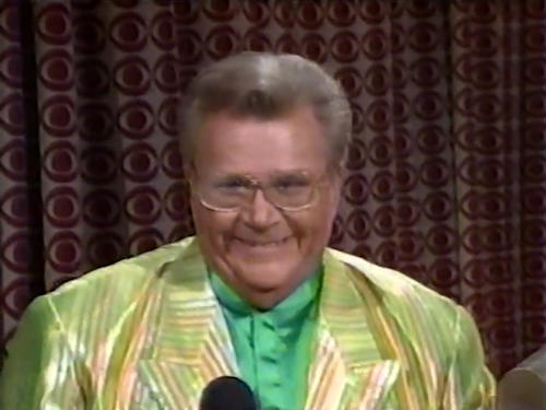 Rod is wearing a shiny yellow-lime green-orange striped jacket & green collarless silk shirt
