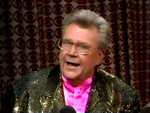 Rod is wearing a gold sequined jacket & pink collarless silk shirt