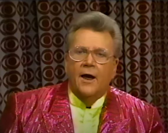 Rod is wearing a shiny red/red-striped jacket & yellow collarless silk shirt