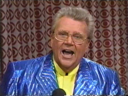 Rod is wearing a shiny periwinkle-striped jacket & yellow collarless silk shirt