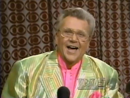 Rod is wearing a shiny citrus-green & yellow striped jacket with pink silk collarless shirt & matching pocket square