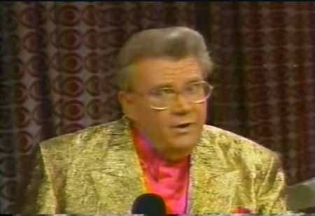 Rod is wearing a gold sequined jacket & salmon collarless silk shirt with matching pocket square