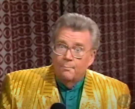 Rod is wearing a shiny yellow jacket w/stripes & green collarless silk shirt