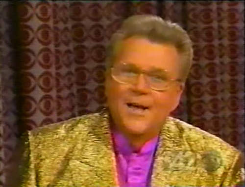 Rod is wearing a gold sequined jacket & fuchsia collarless silk shirt