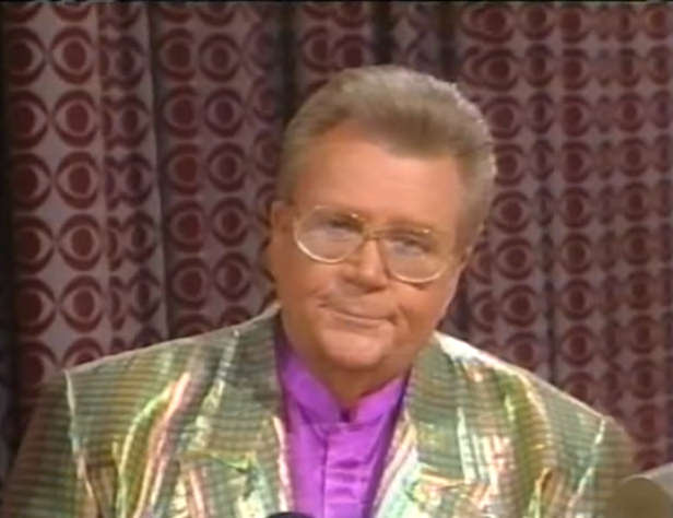 Rod is wearing a holographic-gold jacket & fuchsia collarless silk shirt