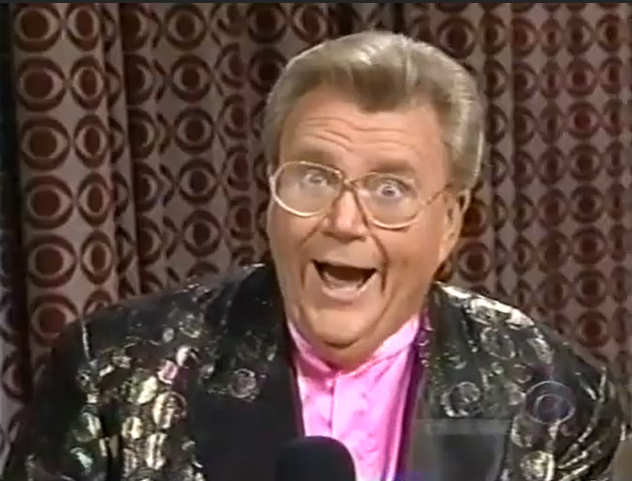 Rod is wearing a black jacket with spots, black lapels & pink collarless silk shirt