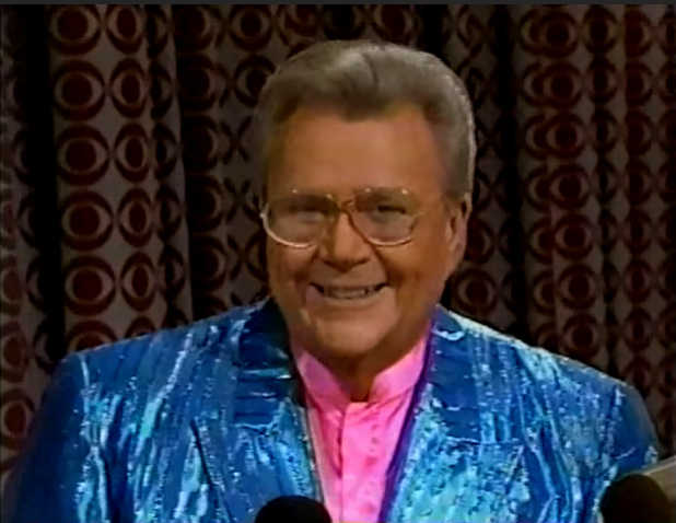 Rod is wearing a shiny blue/blue-striped jacket & pink collarless silk shirt