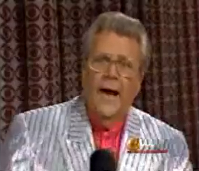Rod is wearing a shiny silver/silver-striped jacket & salmon collarless silk shirt