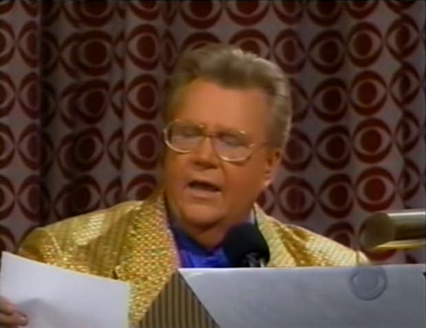 Rod is wearing a gold jacket & blue collarless silk shirt