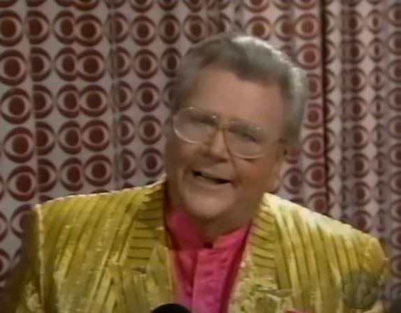 Rod is wearing a yellow/yellow striped jacket & pink collarless silk shirt