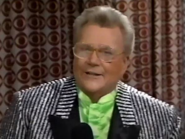 Rod is wearing a glittery black & white striped jacket w/ black lapels jacket & lime green collarless silk shirt