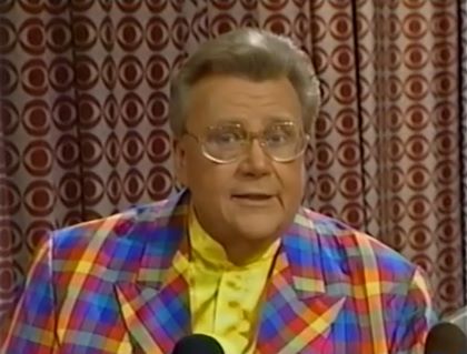 Rod is wearing a multi-colored gingham jacket & yellow collarless silk shirt