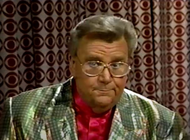Rod is wearing a shiny gold jacket & red silk collarless shirt
