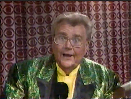 Rod is wearing a shiny green jacket with black lapels & yellow collarless silk shirt