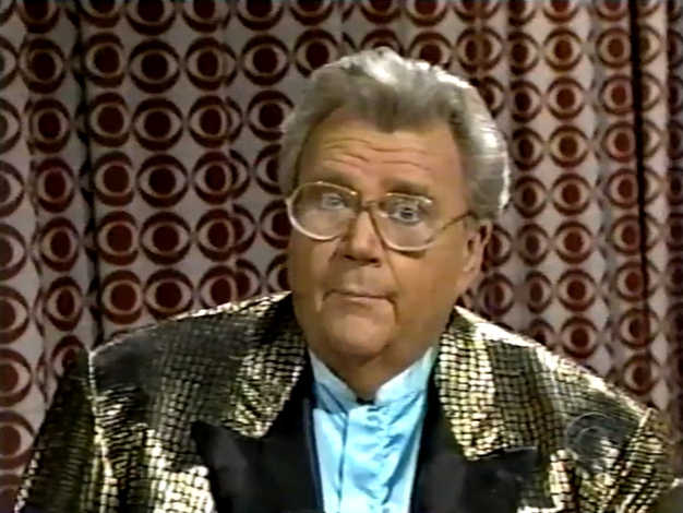 Rod is wearing a gold-dotted jacket with black lapels & powder-blue collarless silk shirt