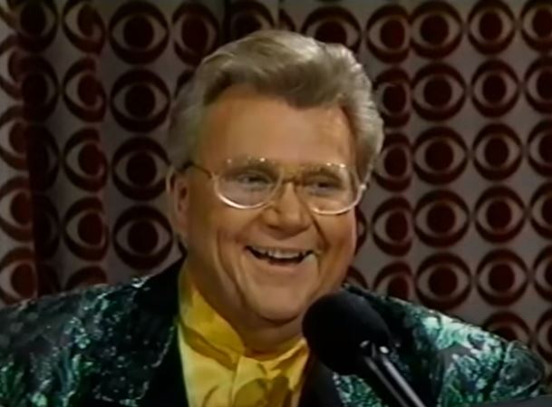 Rod is wearing a green-mottled jacket with black lapels & yellow collarless silk shirt