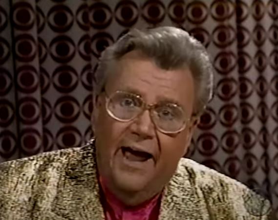 Rod is wearing a shiny gold jacket & fuschia silk collarless shirt