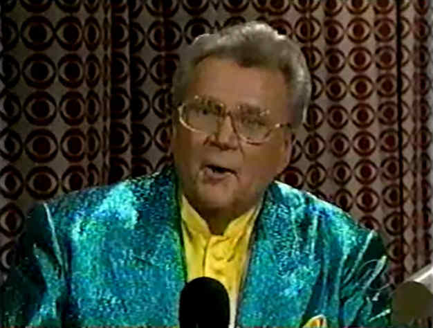 Rod is wearing a seafoam-green sequined jacket & yellow collarless silk shirt with matching pocket square