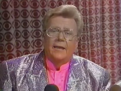 Rod is wearing a silver sequined jacket & pink collarless silk shirt
