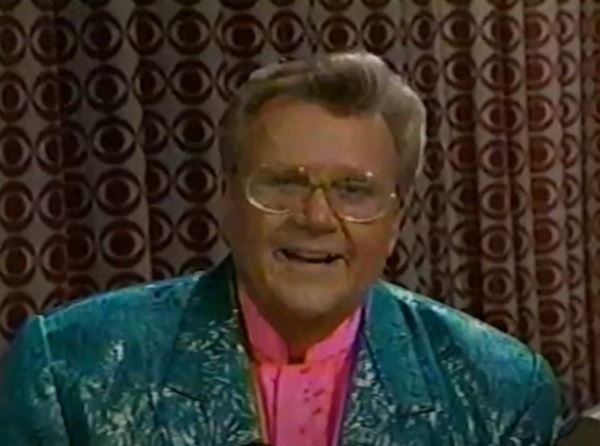 Rod is wearing a shiny seafoam-green jacket & pink collarless silk shirt