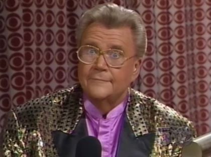 Rod is wearing a shiny gold jacket with black spots, black lapels & violet collarless silk shirt