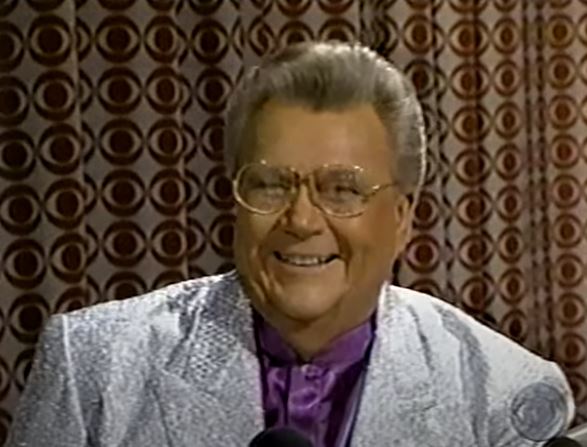 Rod is wearing a sparkly silver jacket & purple silk collarless shirt