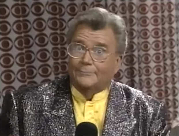 Rod is wearing a sparkly silver jacket & yellow collarless silk shirt