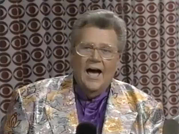 Rod is wearing a shimmery flower-print jacket & purple collarless silk shirt