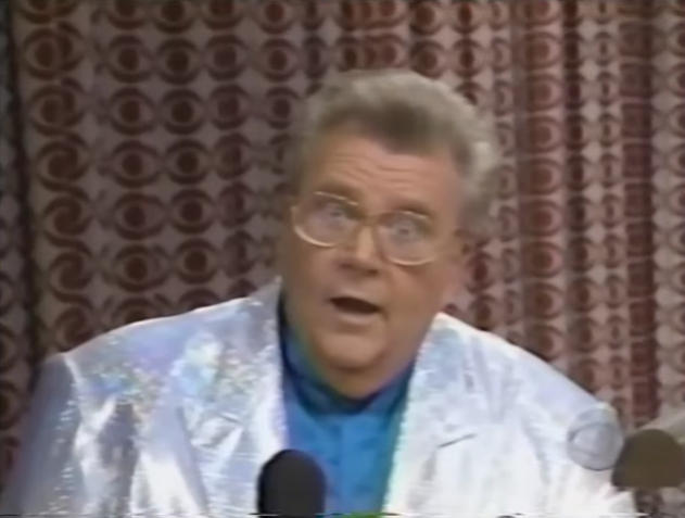 Rod is wearing a silver sequined jacket & blue collarless silk shirt