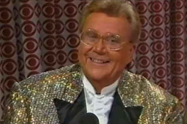 Rod is wearing a gold sequined jacket with black lapels & white collarless silk shirt
