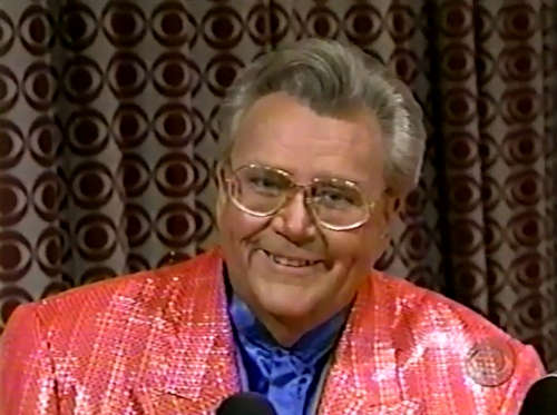 Rod is wearing a pink sequined jacket & blue collarless silk shirt